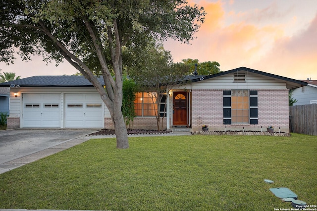 single story home featuring concrete driveway, a lawn, and brick siding