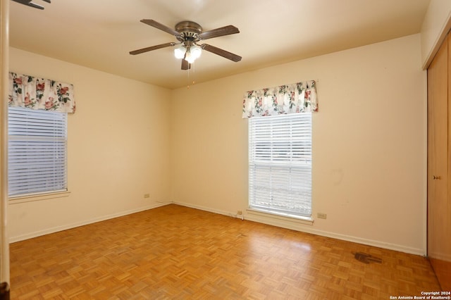 spare room featuring a ceiling fan and baseboards