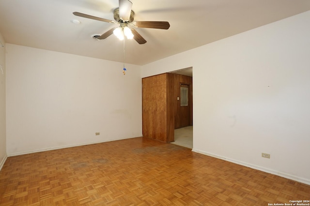 spare room featuring ceiling fan and baseboards