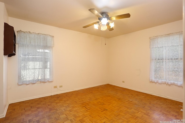 unfurnished room featuring a ceiling fan and baseboards