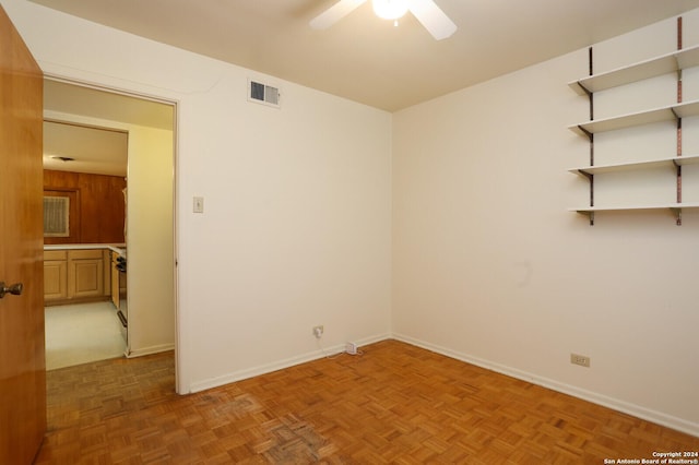 empty room featuring baseboards, visible vents, and a ceiling fan