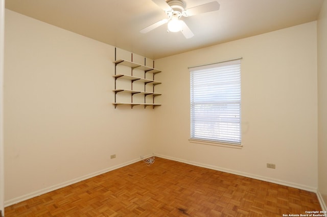 spare room with ceiling fan and baseboards