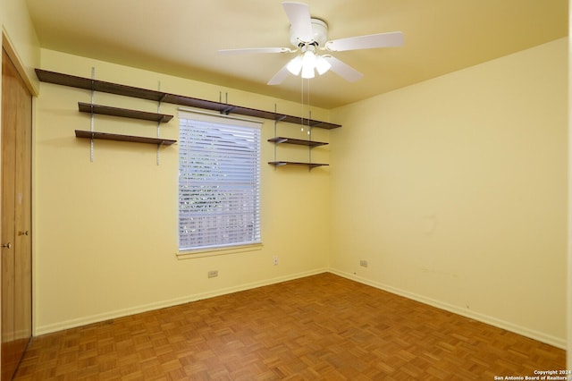 empty room featuring ceiling fan and baseboards