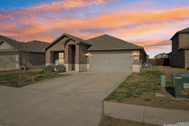 view of front of house with brick siding, roof with shingles, concrete driveway, a garage, and stone siding