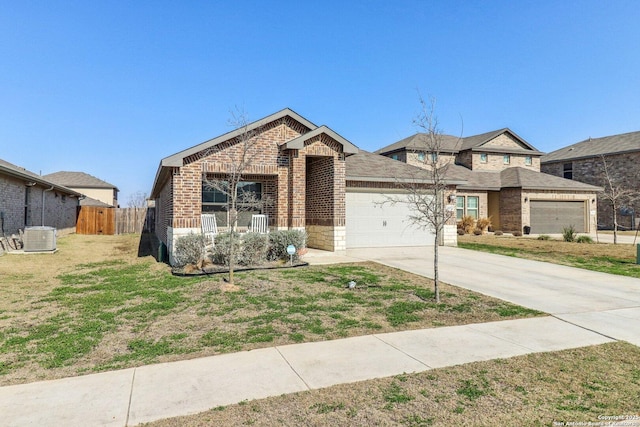 view of front of house with an attached garage, brick siding, fence, concrete driveway, and a front lawn