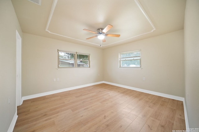 spare room with light wood-style flooring, baseboards, and a ceiling fan