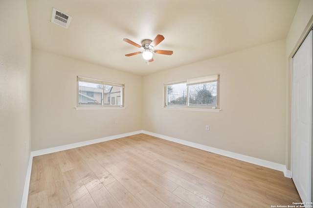 unfurnished bedroom featuring a closet, visible vents, light wood-style flooring, a ceiling fan, and baseboards