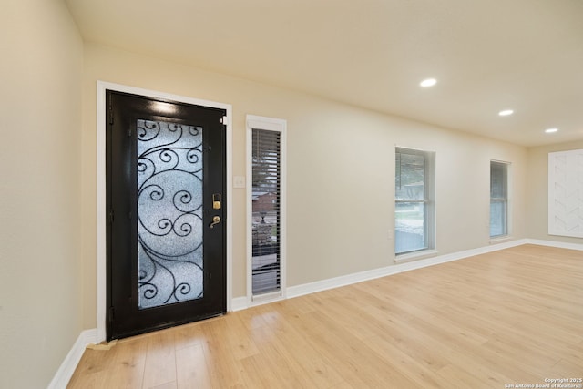 foyer entrance with light wood-style floors, recessed lighting, and baseboards