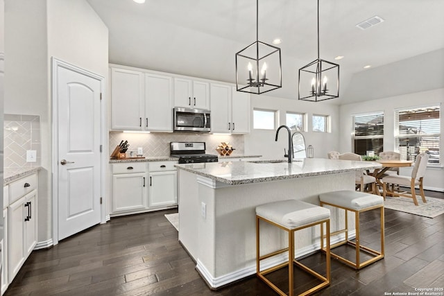 kitchen with visible vents, stainless steel appliances, a sink, and dark wood finished floors