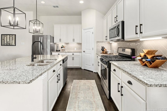 kitchen with dark wood-type flooring, a sink, visible vents, white cabinetry, and appliances with stainless steel finishes