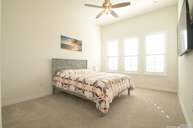 bedroom with a ceiling fan, carpet flooring, and baseboards