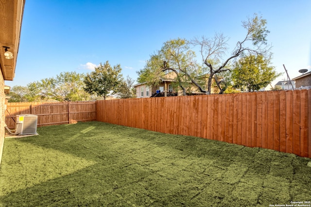 view of yard featuring a fenced backyard and central air condition unit