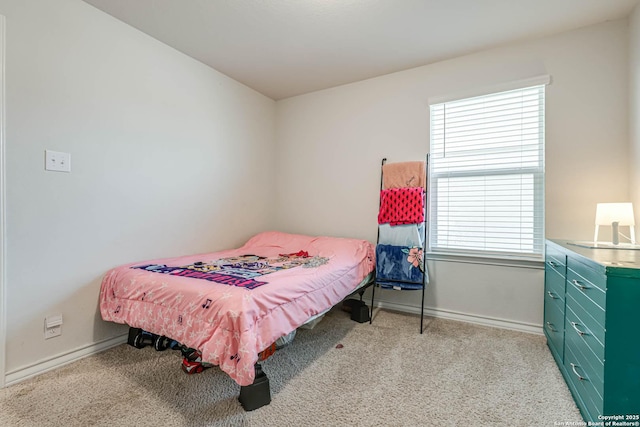 bedroom featuring light carpet and baseboards