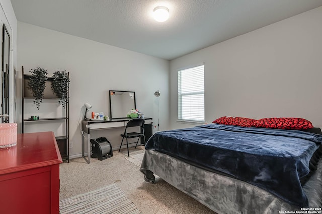 bedroom with carpet, baseboards, and a textured ceiling