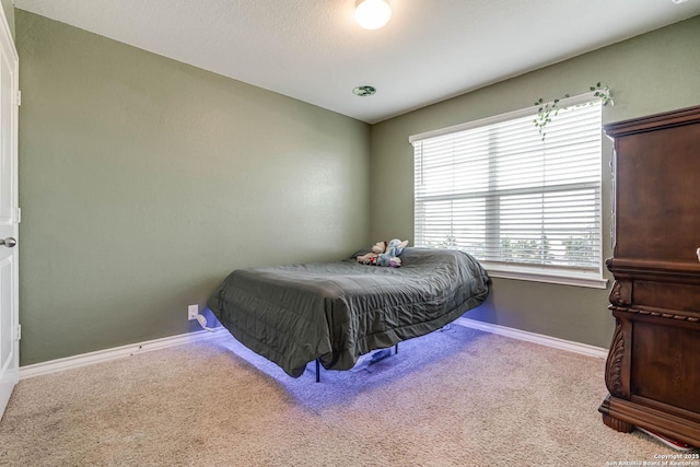 bedroom featuring carpet and baseboards