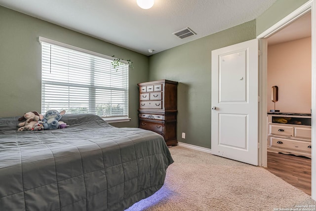 bedroom featuring light carpet, baseboards, and visible vents