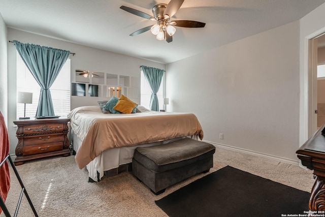 carpeted bedroom featuring ceiling fan, multiple windows, and baseboards