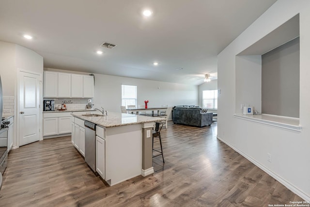 kitchen featuring visible vents, white cabinetry, a sink, wood finished floors, and dishwasher