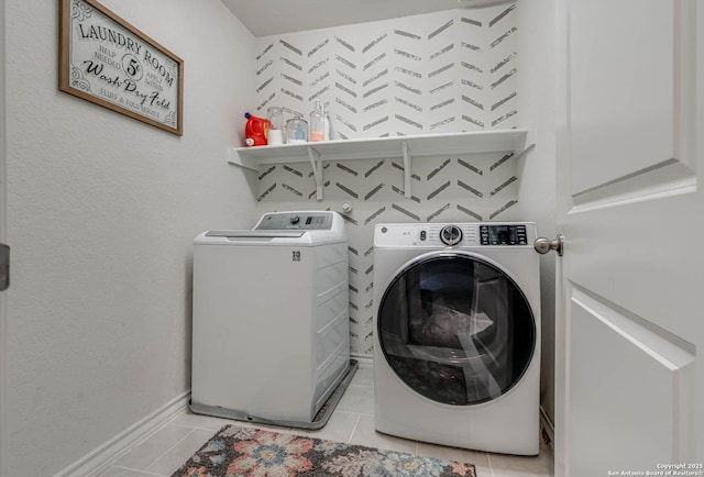 laundry room with laundry area, light tile patterned floors, baseboards, and separate washer and dryer