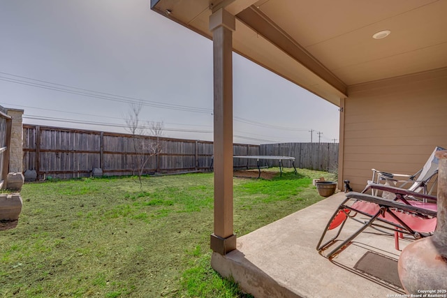 view of yard featuring a patio, a trampoline, and a fenced backyard