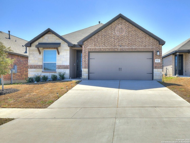 view of front facade with a garage, stone siding, driveway, and brick siding