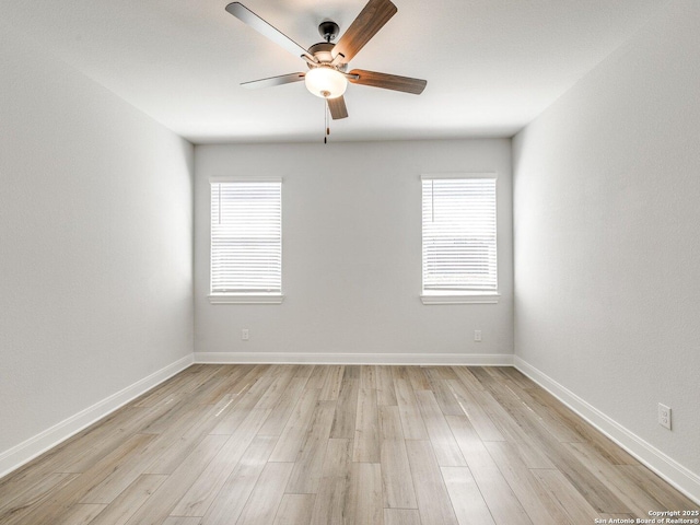 empty room with baseboards, light wood-style flooring, and a healthy amount of sunlight