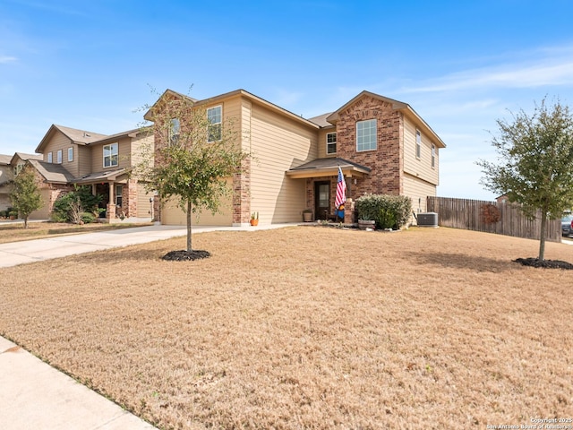 traditional-style home with central AC unit, concrete driveway, an attached garage, fence, and brick siding