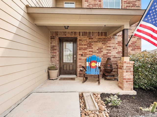 view of exterior entry featuring brick siding