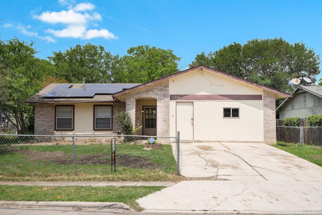 ranch-style house featuring concrete driveway, brick siding, a fenced front yard, and roof mounted solar panels