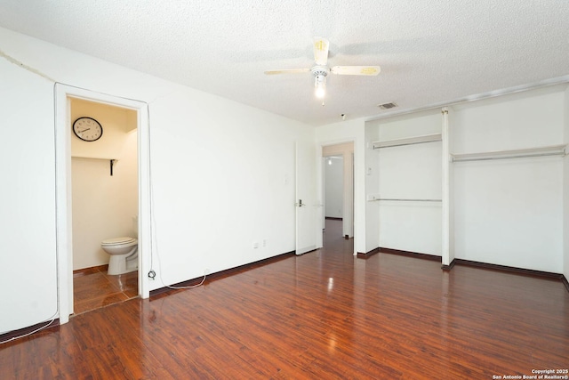 unfurnished bedroom featuring a textured ceiling, visible vents, wood finished floors, a closet, and connected bathroom