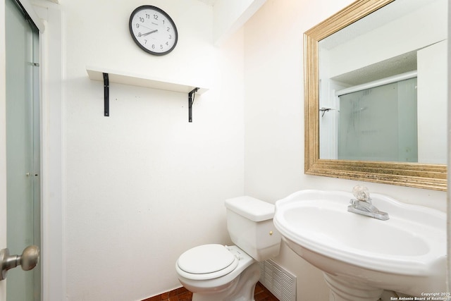 full bathroom featuring toilet, visible vents, a shower stall, and a sink