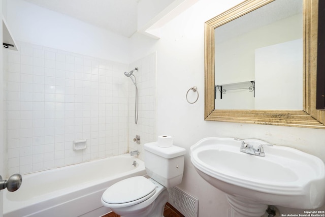 bathroom featuring visible vents, a sink, shower / bathing tub combination, and toilet