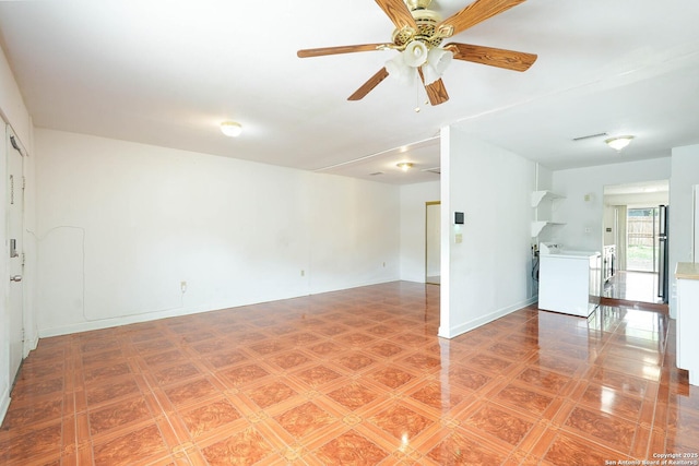 unfurnished room with ceiling fan and washer / dryer