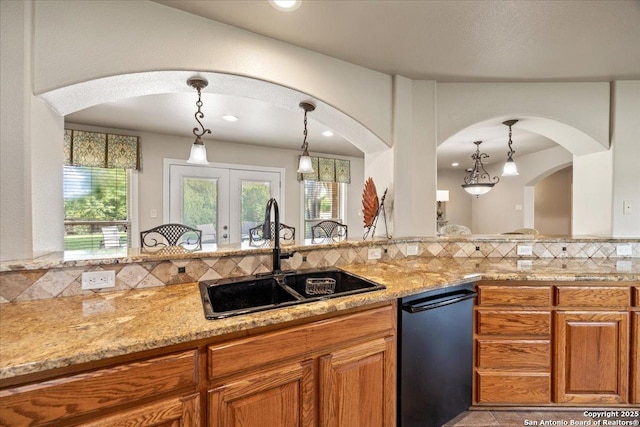 6822 Moss Oak, San Antonio, TX 78229 - kitchen featuring a sink, arched walkways, brown cabinetry, dishwashing machine, and recessed lighting