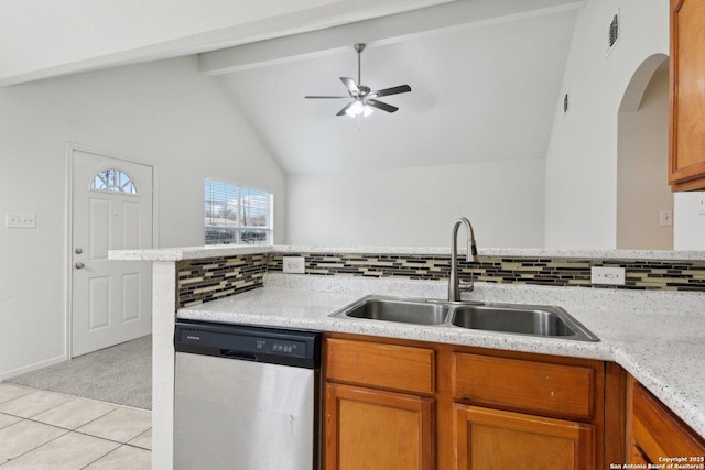 kitchen featuring ceiling fan, vaulted ceiling with beams, a sink, brown cabinets, and dishwasher