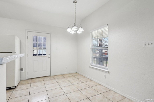 unfurnished dining area with lofted ceiling, plenty of natural light, light tile patterned flooring, and a notable chandelier