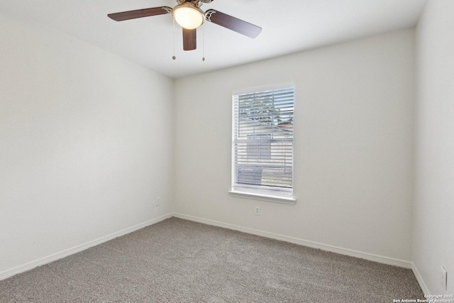 carpeted empty room featuring a ceiling fan and baseboards