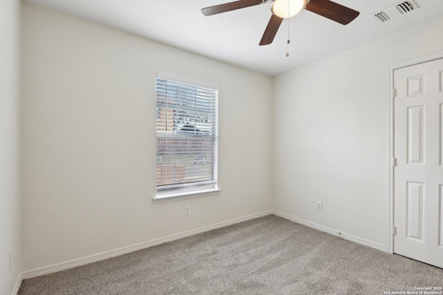 unfurnished room with carpet, visible vents, ceiling fan, and baseboards