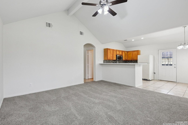 unfurnished living room featuring arched walkways, light colored carpet, ceiling fan with notable chandelier, visible vents, and beam ceiling