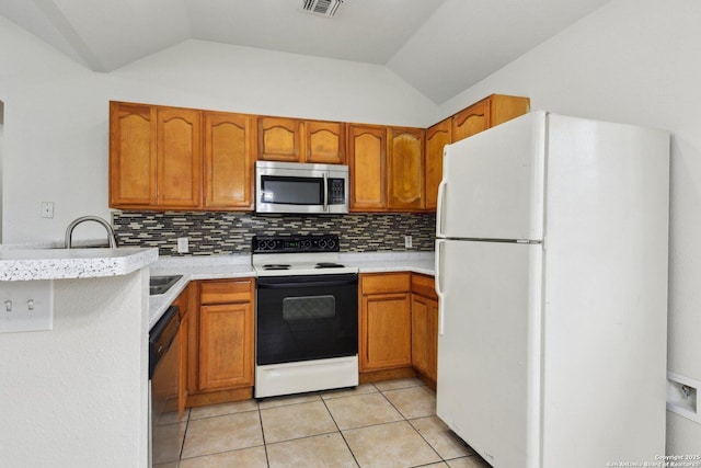 kitchen featuring black dishwasher, stainless steel microwave, electric range, freestanding refrigerator, and a peninsula