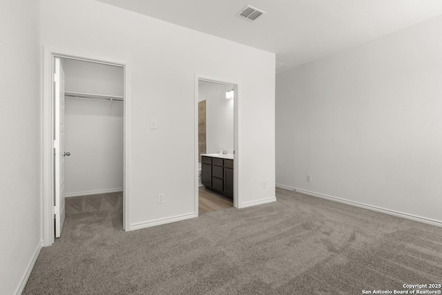 9538 Reinhartz Way, San Antonio, TX 78221 - unfurnished bedroom with light colored carpet, a spacious closet, baseboards, a closet, and connected bathroom