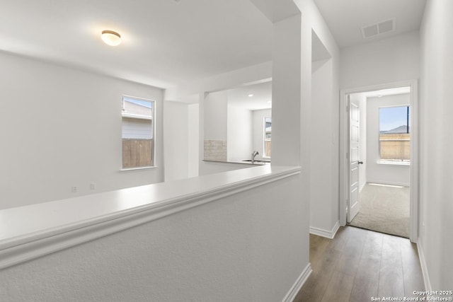 9538 Reinhartz Way, San Antonio, TX 78221 - hallway featuring hardwood / wood-style floors, baseboards, and a sink