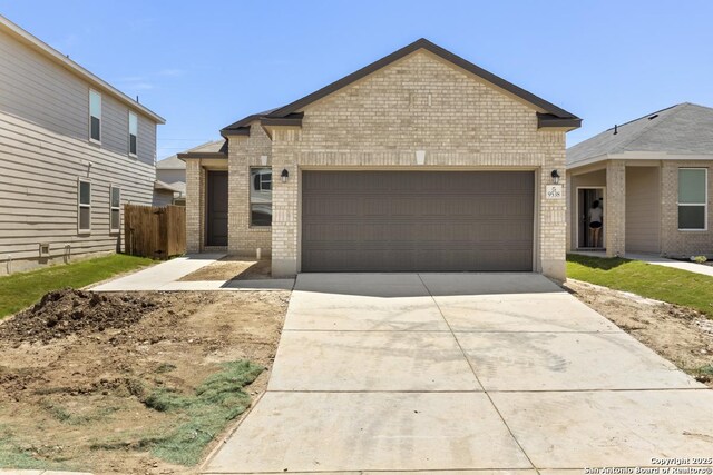 9538 Reinhartz Way, San Antonio, TX 78221 - view of front facade featuring brick siding, an attached garage, concrete driveway, and fence