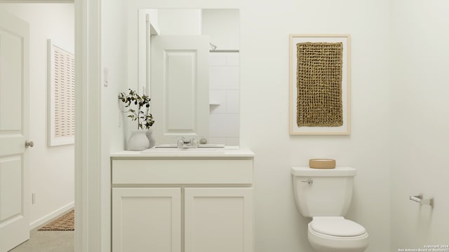 bathroom featuring toilet, baseboards, and vanity