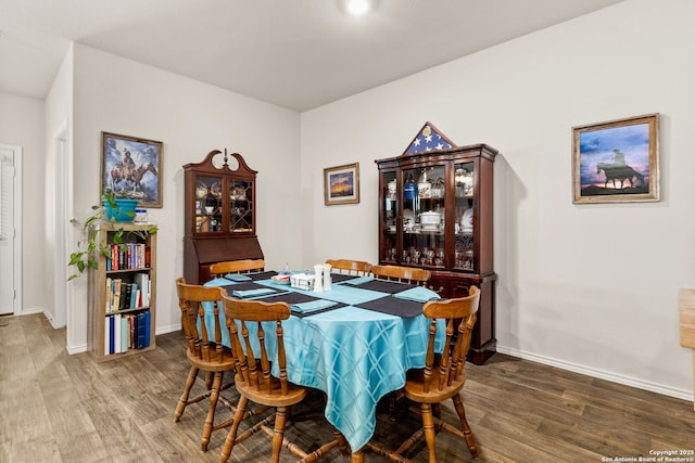 dining space featuring baseboards and wood finished floors