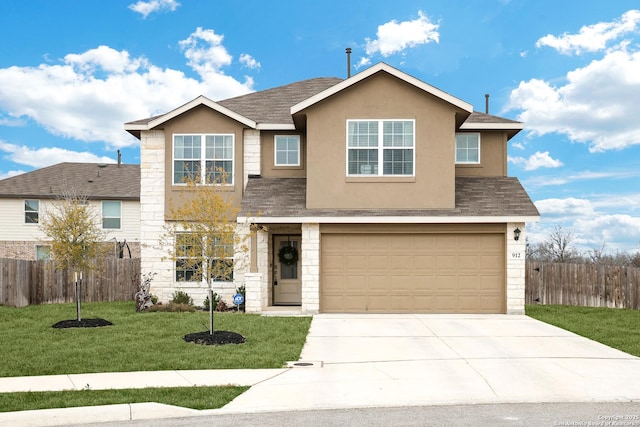 traditional home with concrete driveway, a front lawn, fence, and stucco siding