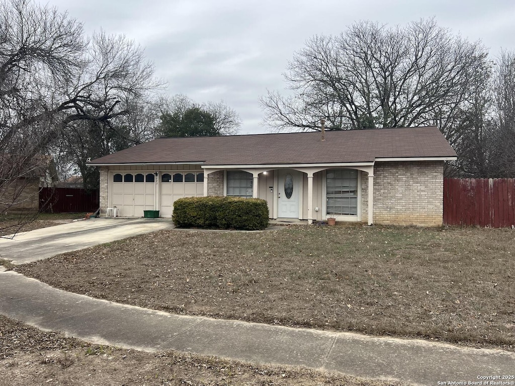 single story home with driveway, a garage, fence, and brick siding