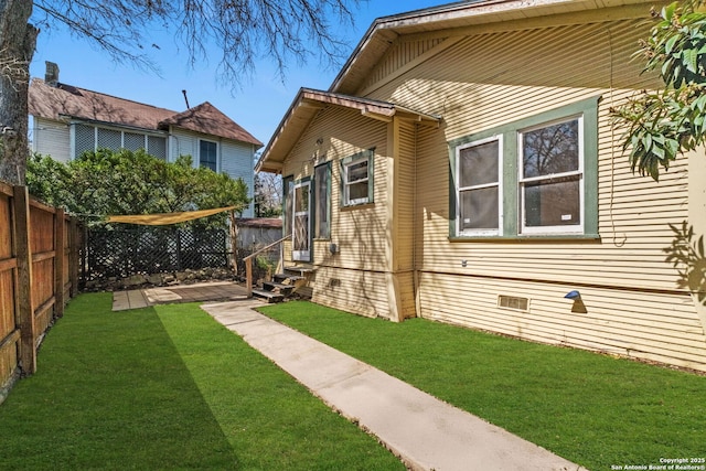 view of yard featuring entry steps and a fenced backyard