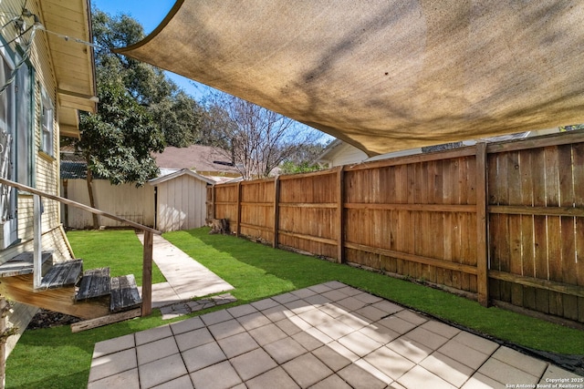 view of yard with a patio area, an outdoor structure, and a fenced backyard