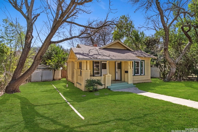 bungalow-style home with a porch, a front lawn, and fence